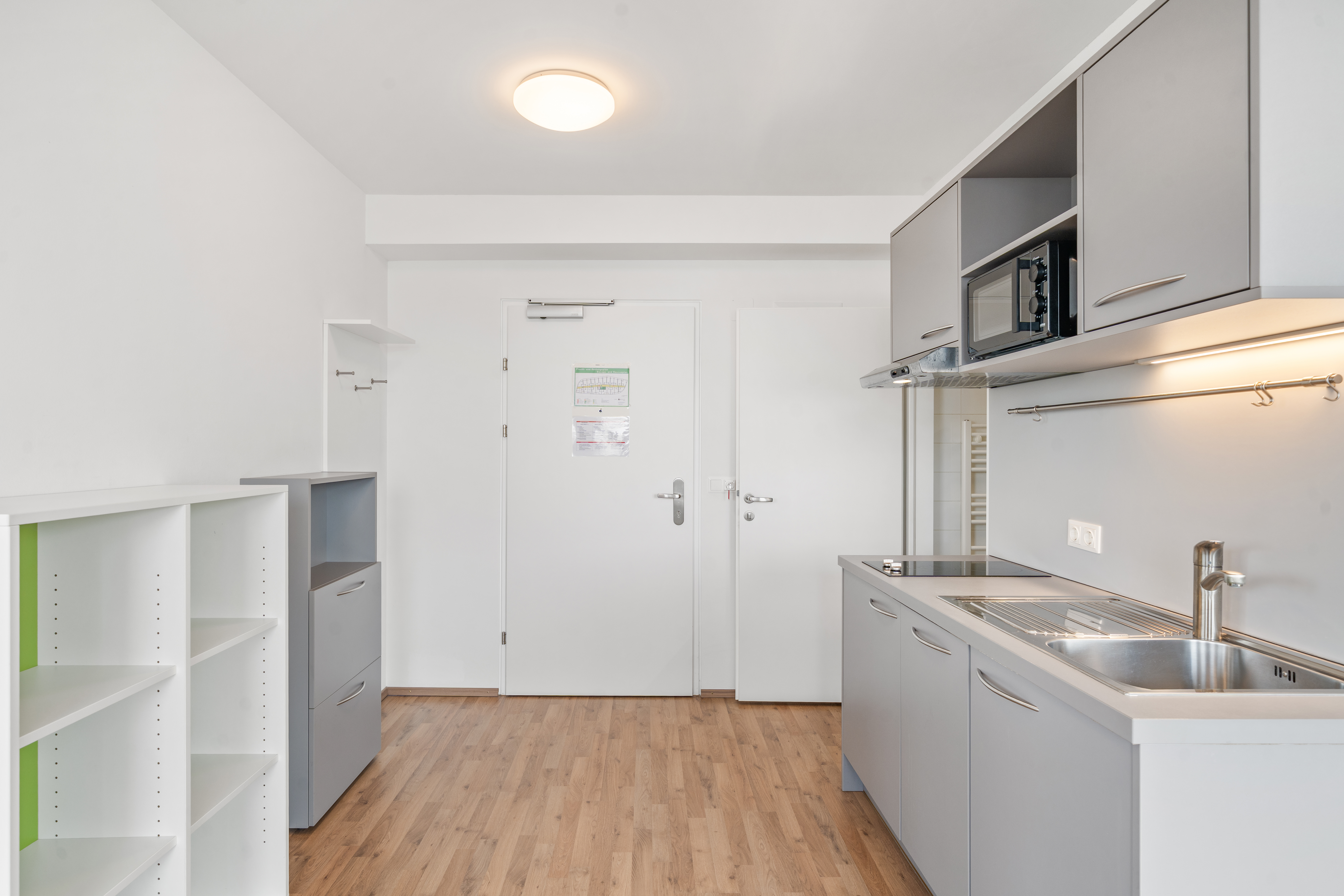 Kitchenette mit Spüle und Kochfeld in einem möblierten Room4Rent Apartment vom Typ L Balcony