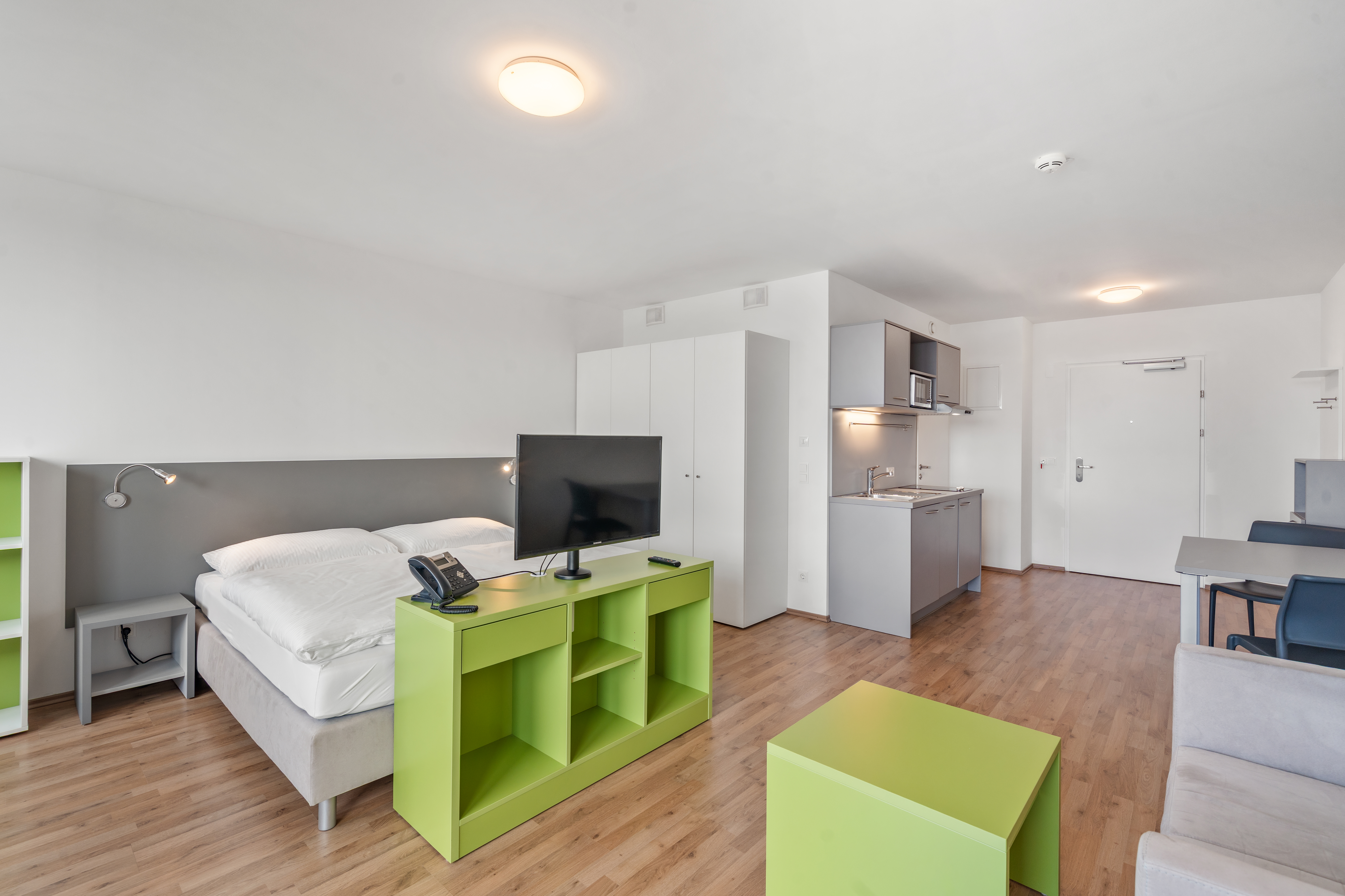 Schlafbereich mit Küchenzeile in einem möblierten Room4Rent Apartment S Balcony im Messecarrée Nord
