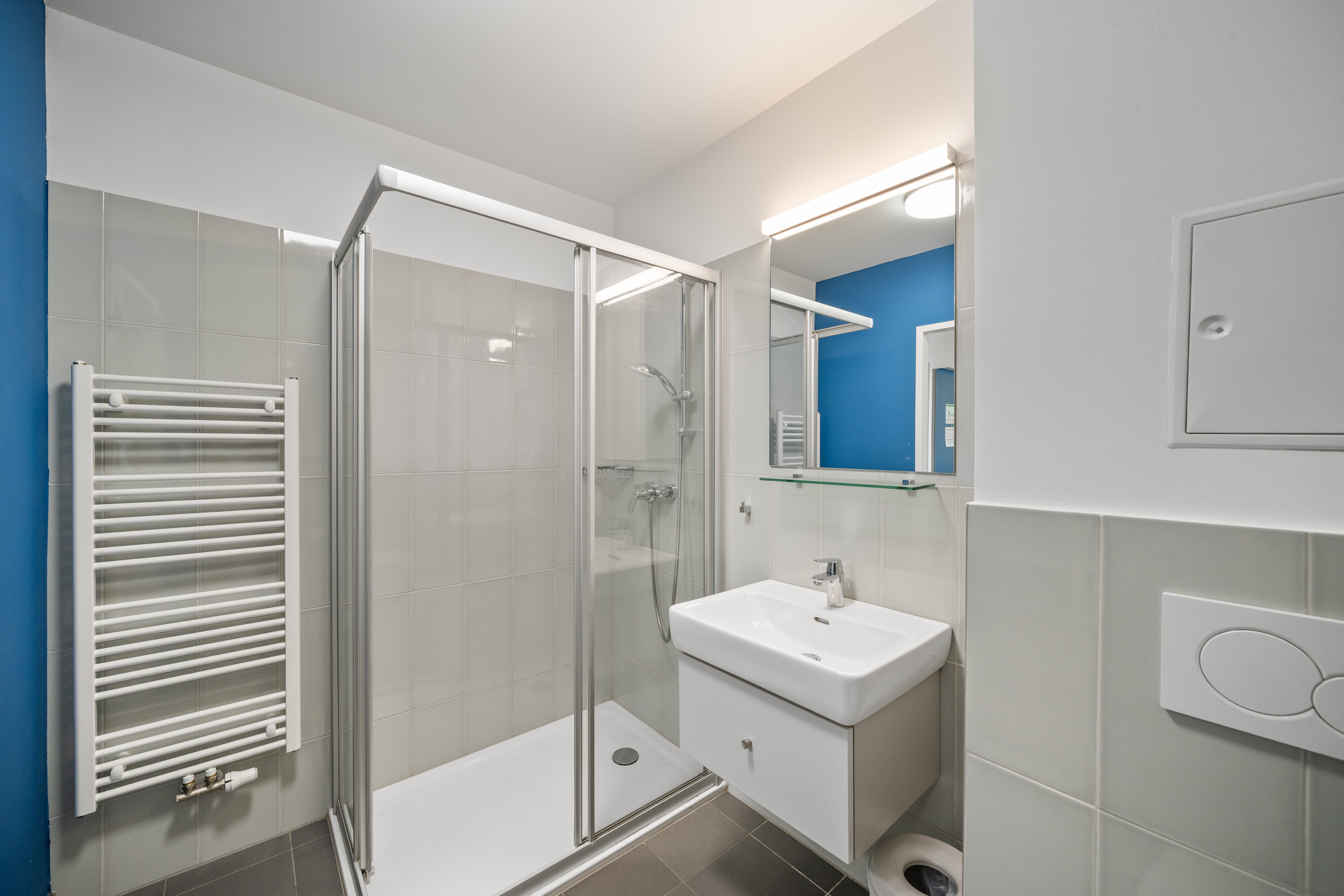 Badezimmer in einem möblierten Apartment der MusicBox Wien mit Duschkabine und modernen Sanitärobjekten