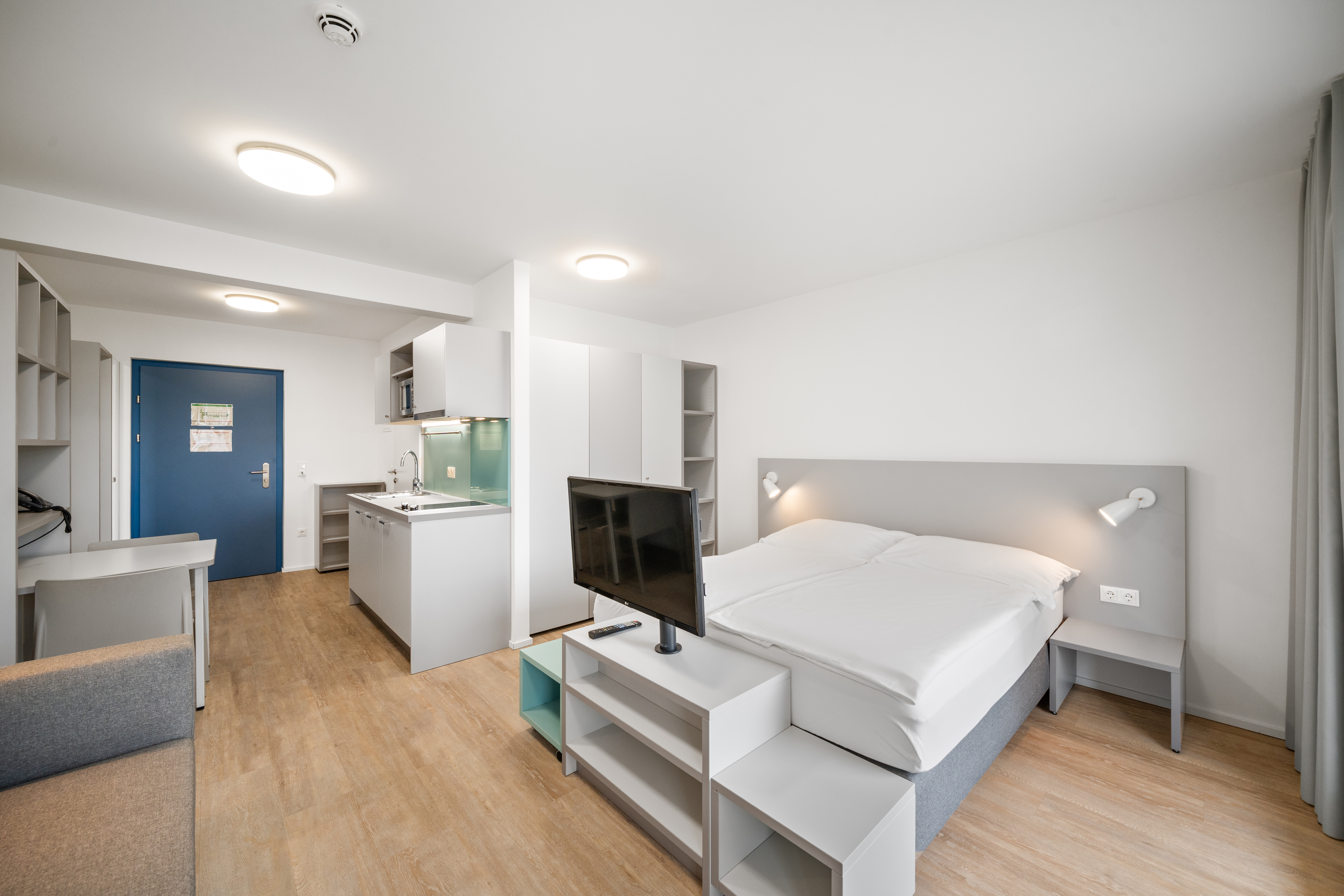Offener Wohnbereich mit integriertem Schlaf- und Arbeitsbereich in einem möblierten Studio-Apartment der MusicBox Wien