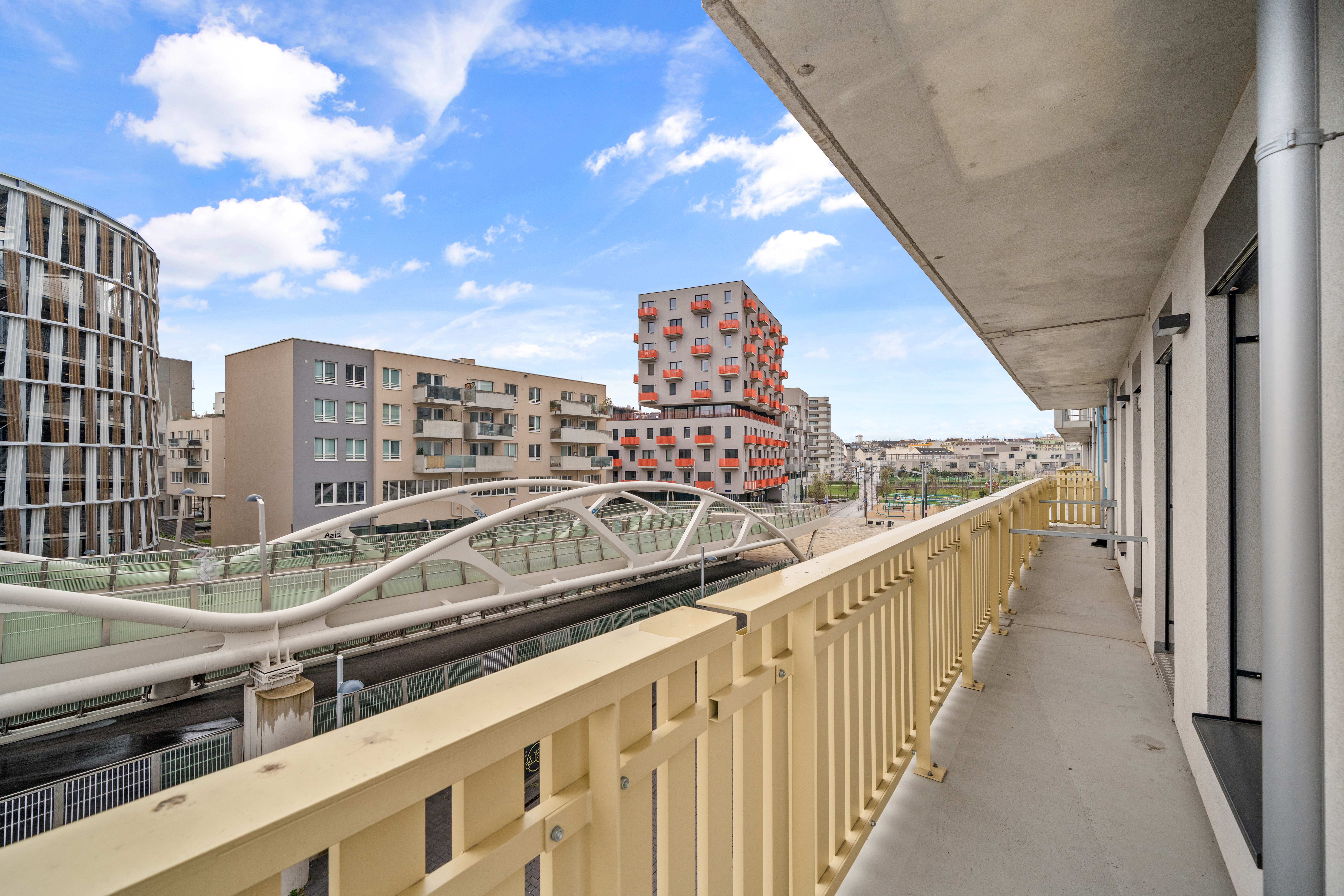 Balkon mit Blick auf die Donau und moderne Wohngebäude vom Room4Rent Serviced Apartment in der MusicBox Wien