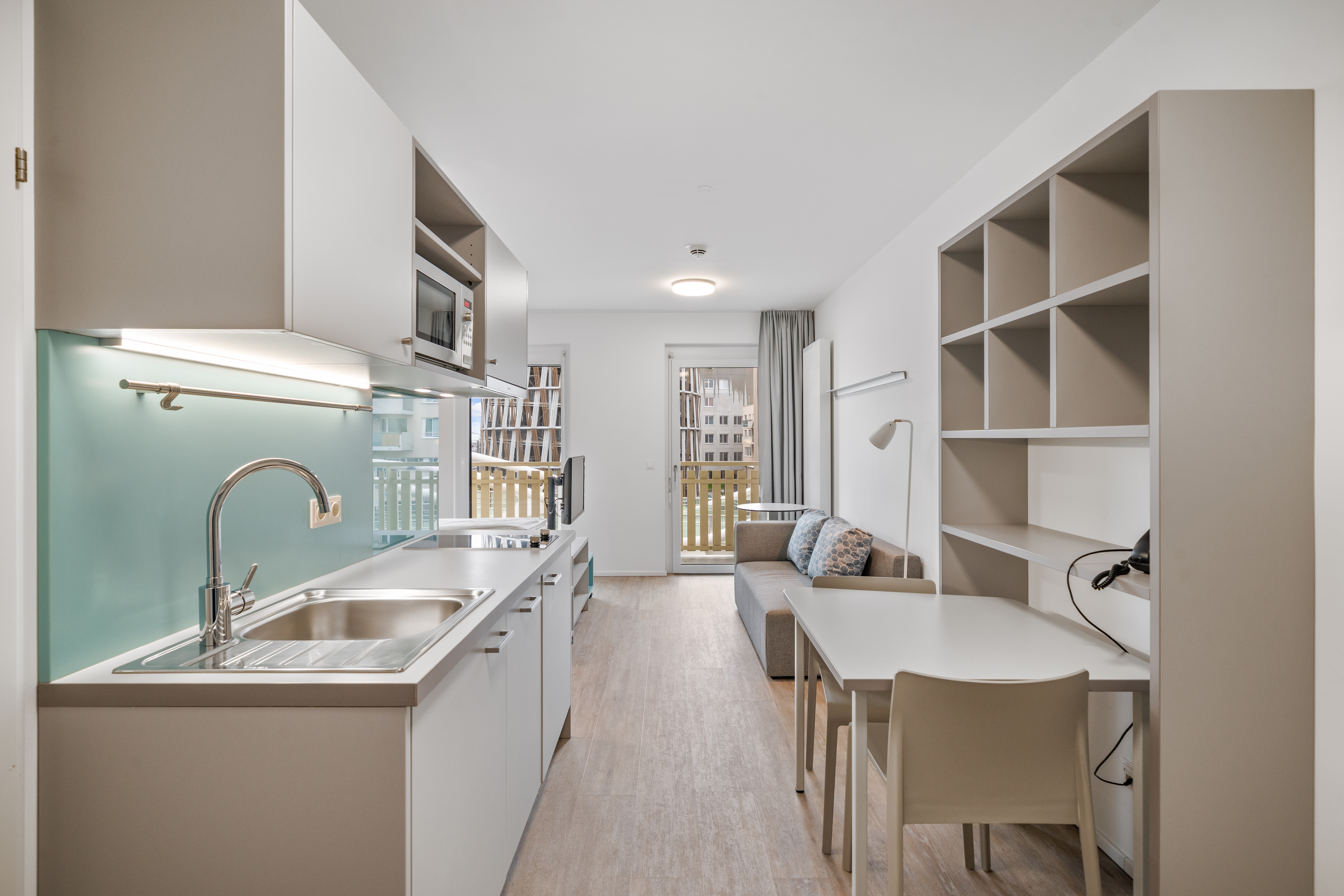 Kompaktes Serviced Apartment mit integrierter Küchenzeile, Essbereich und Arbeitsplatz im Room4Rent Standort Musik Box