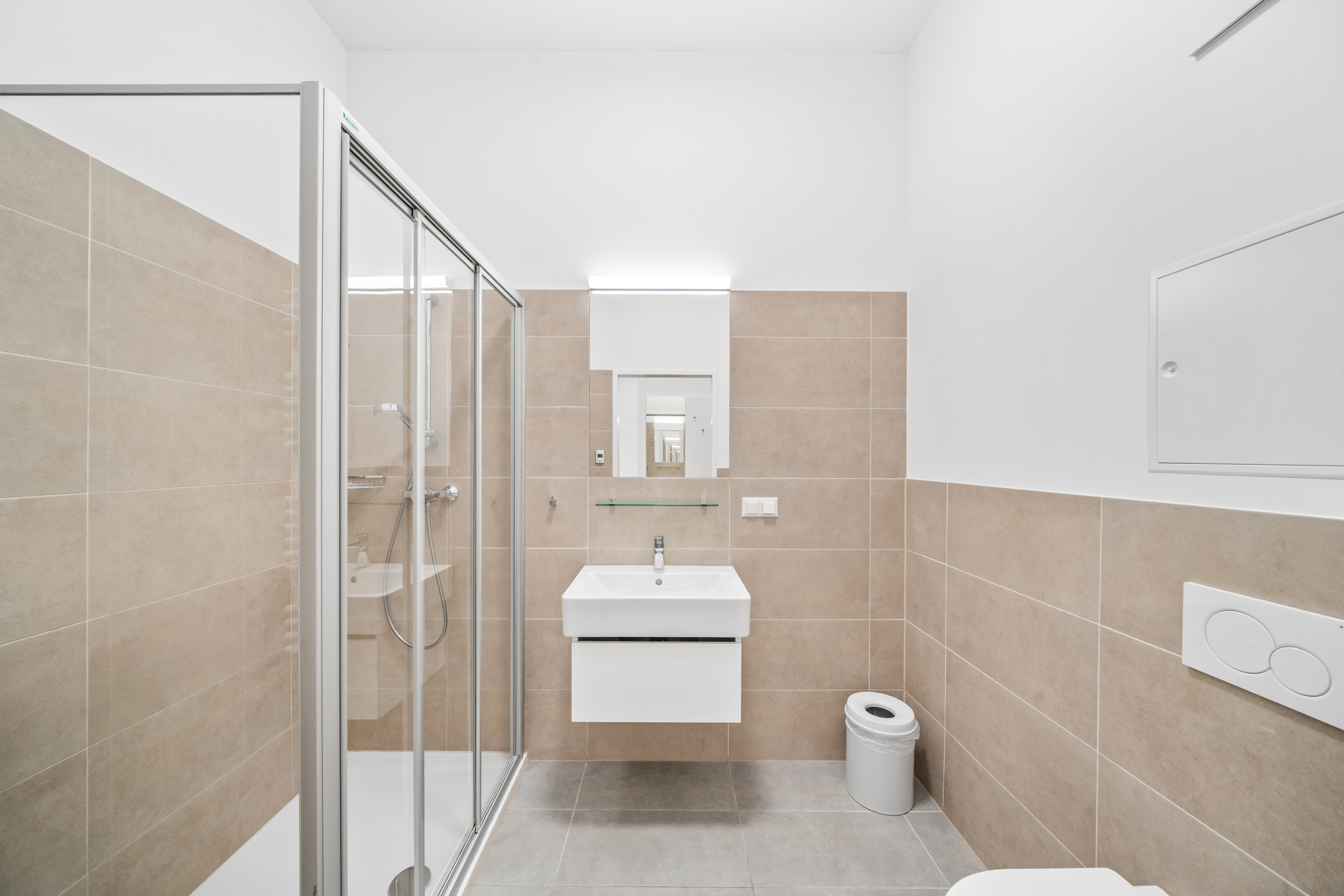Badezimmer mit Dusche, Waschbecken und Toilette in einem Room4Rent Serviced Apartment Typ L