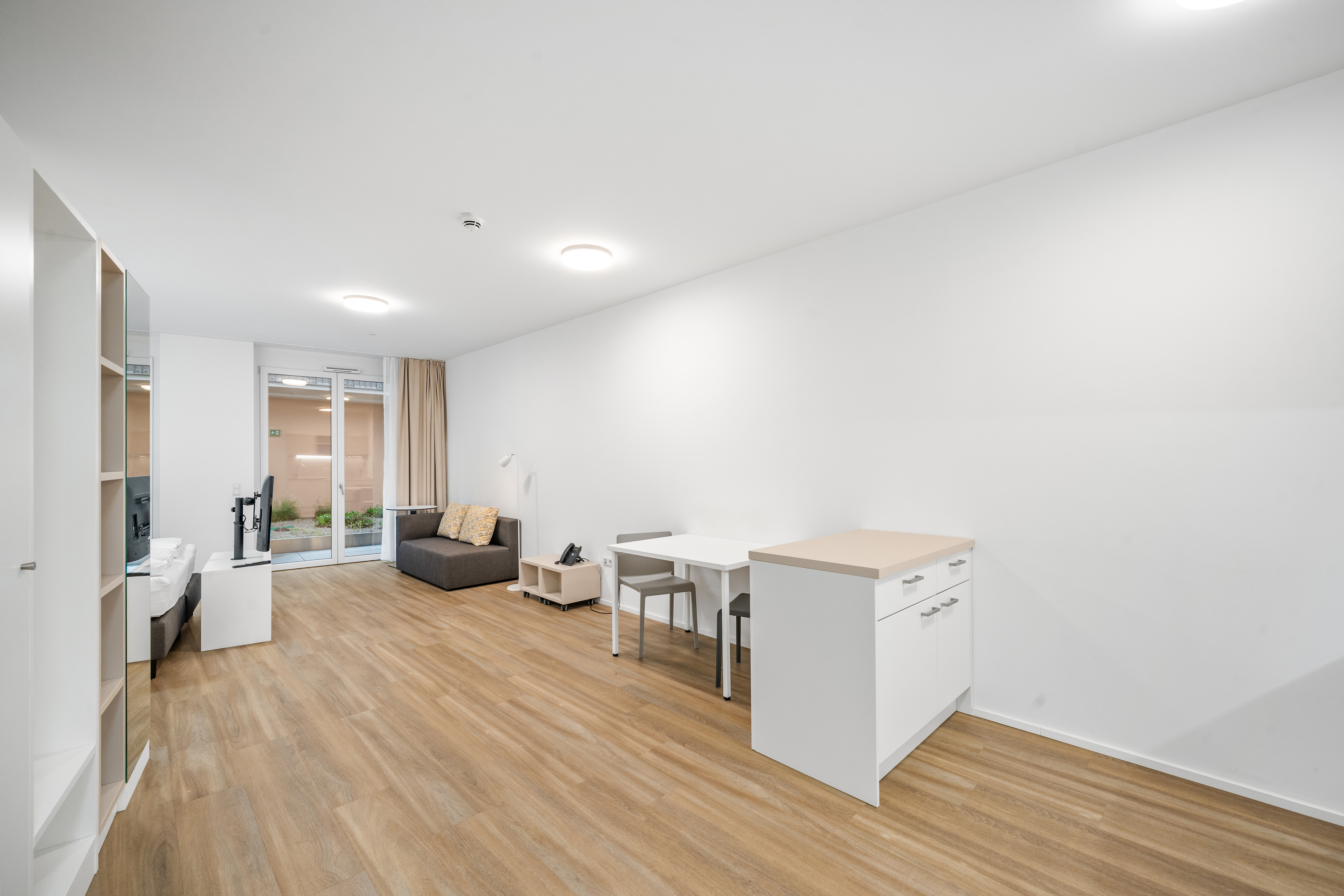 Wohnbereich eines Room4Rent Serviced Apartments im Q-Tower mit Essbereich, Küche und Balkonzugang