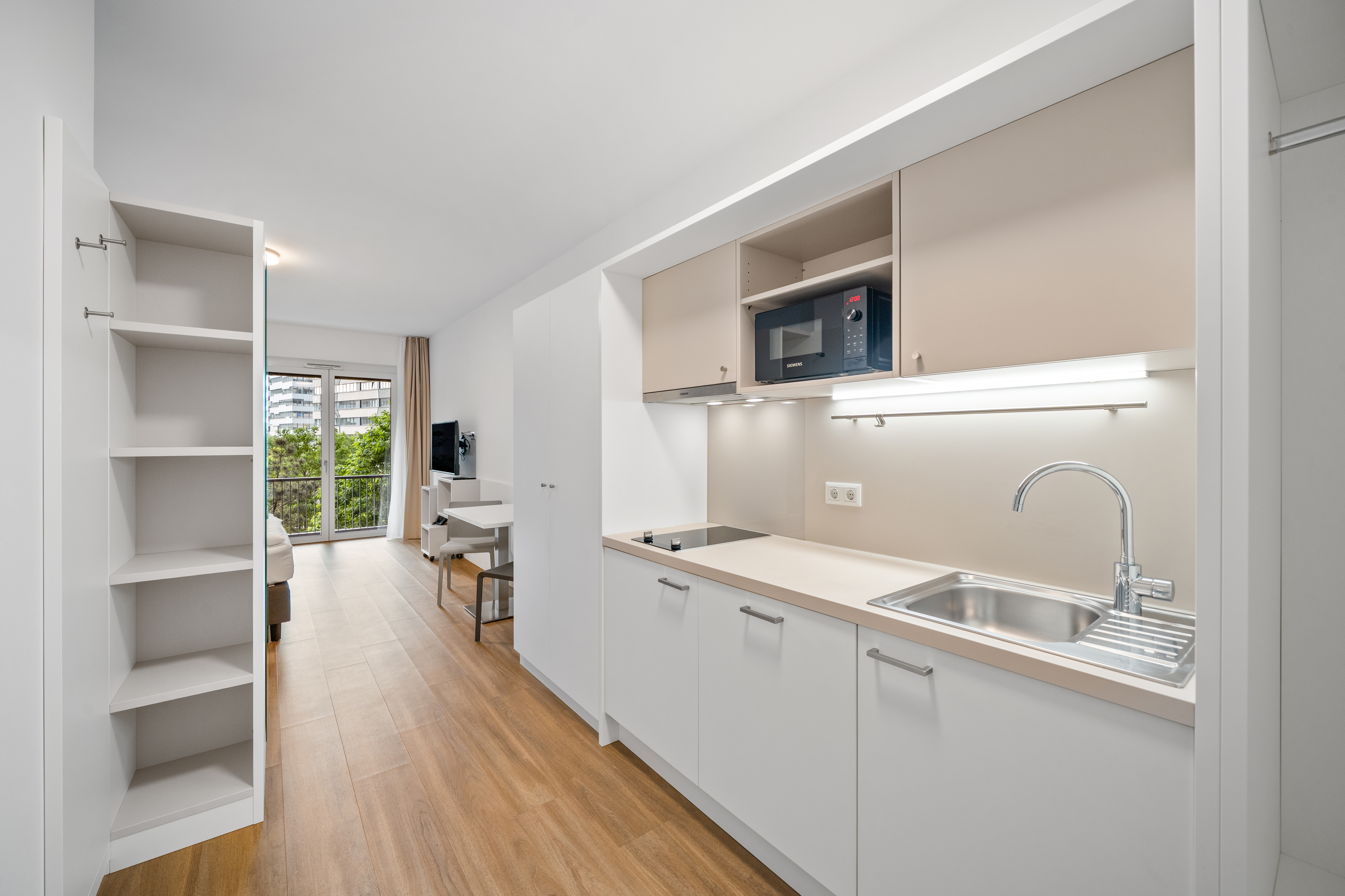 Offene Küche mit Spüle und Herdplatte in einem Room4Rent Apartment im Q-Tower