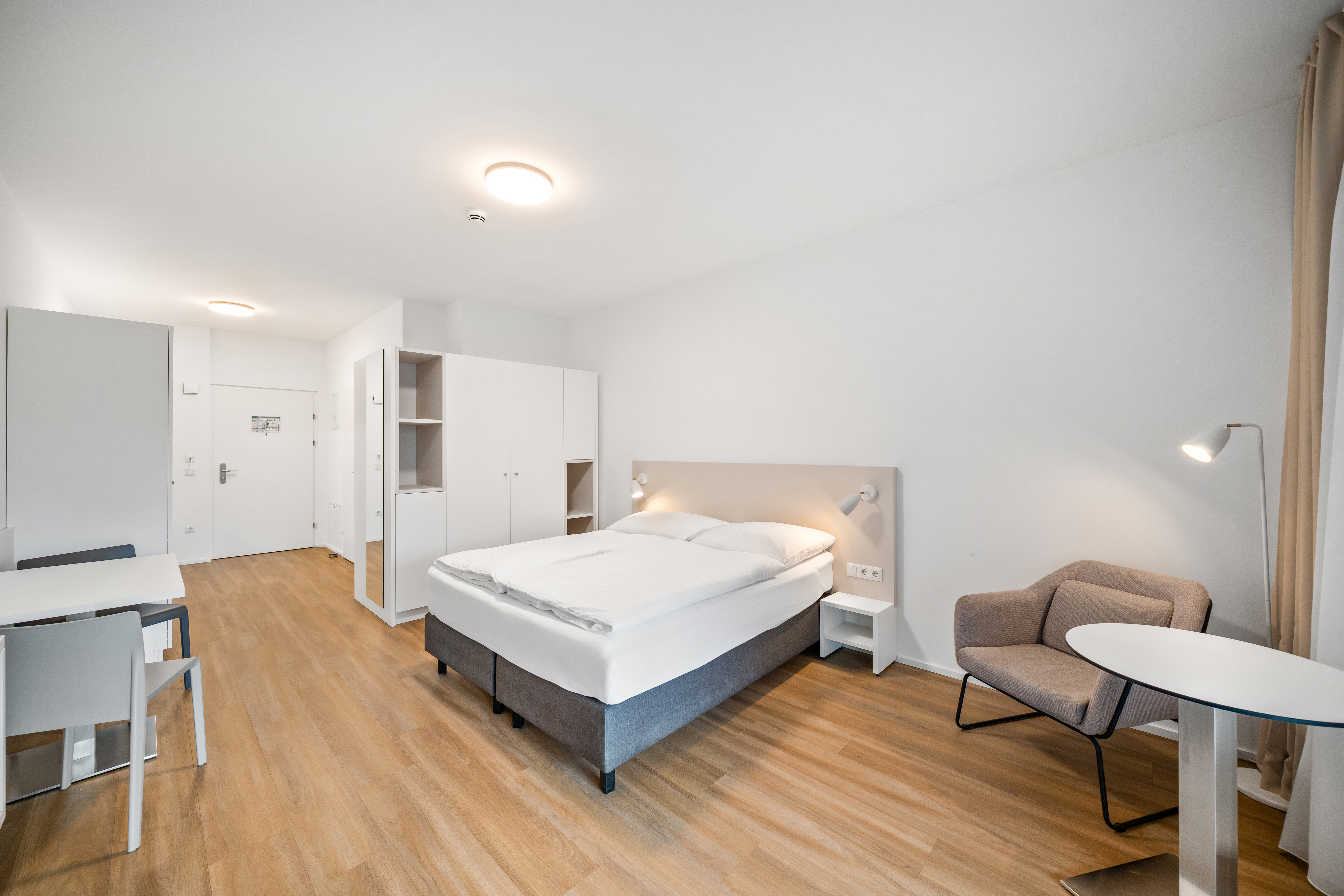 Schlafzimmer mit Doppelbett und Schranksystem in einem möblierten Apartment im Q-Tower Wien