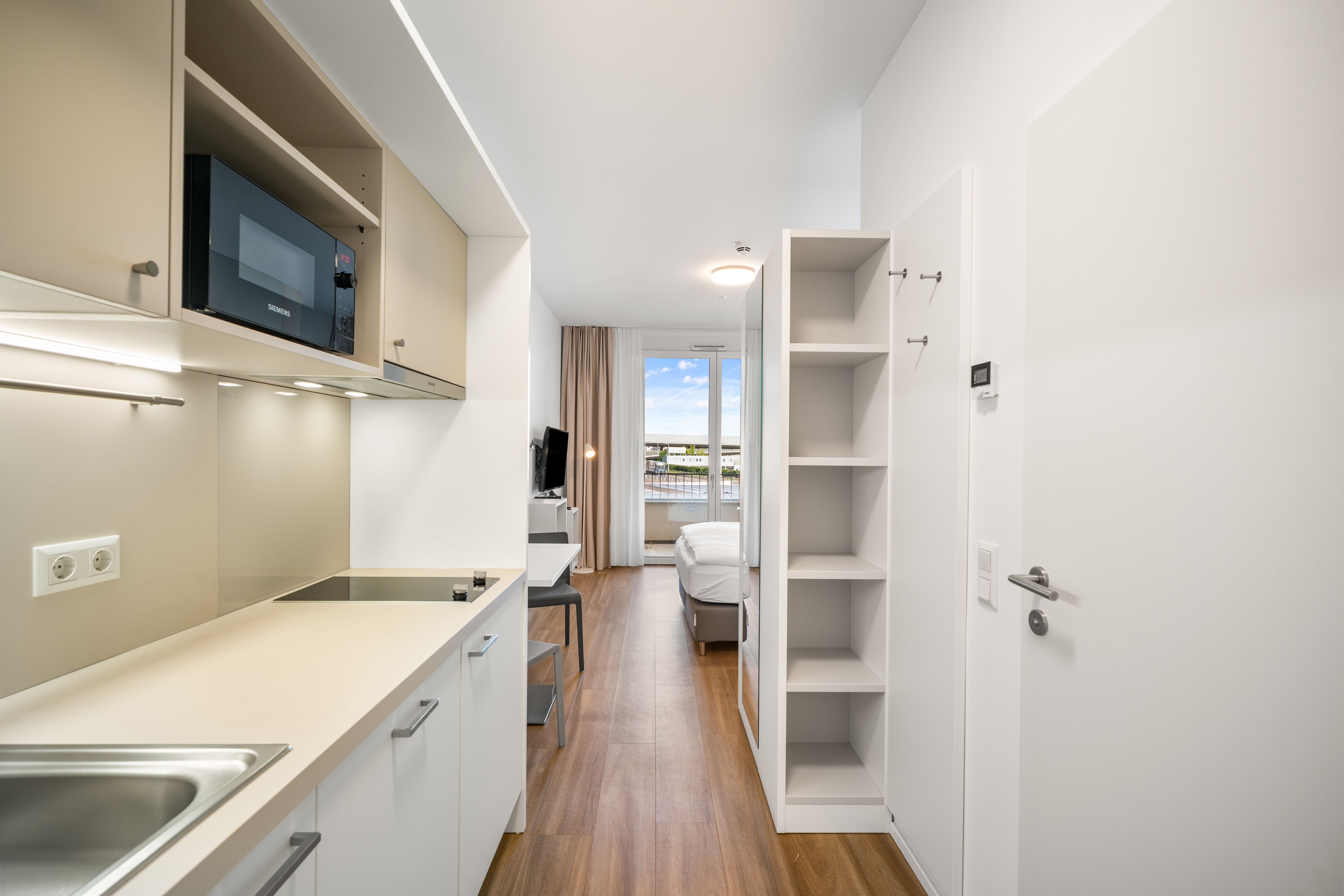 Küchenbereich mit Arbeitsplatz und Essbereich in einem Room4Rent Apartment Typ XS