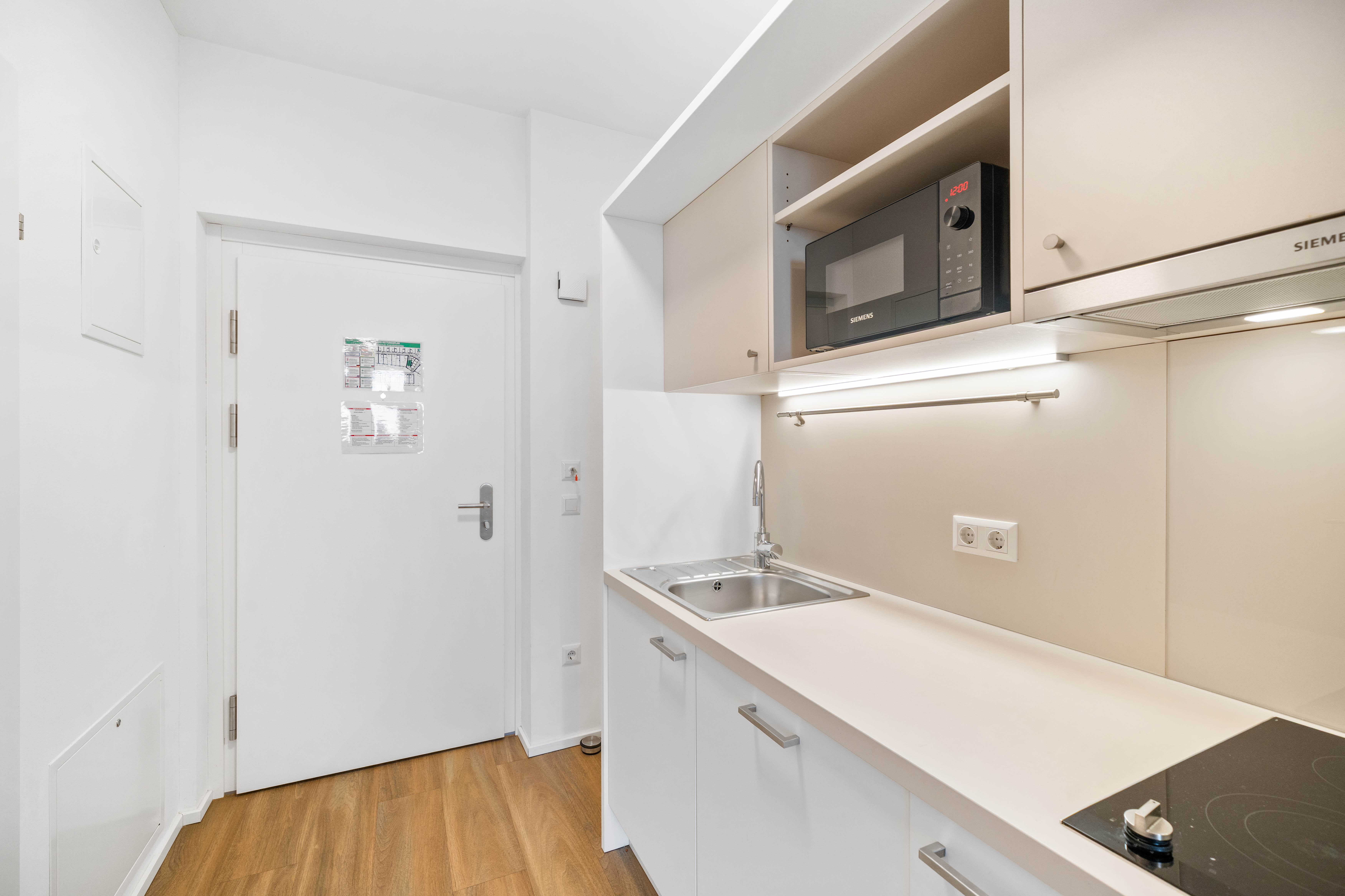Küchenzeile mit Kochfeld, Spüle und Speicherschränken im Room4Rent Apartment Typ XS