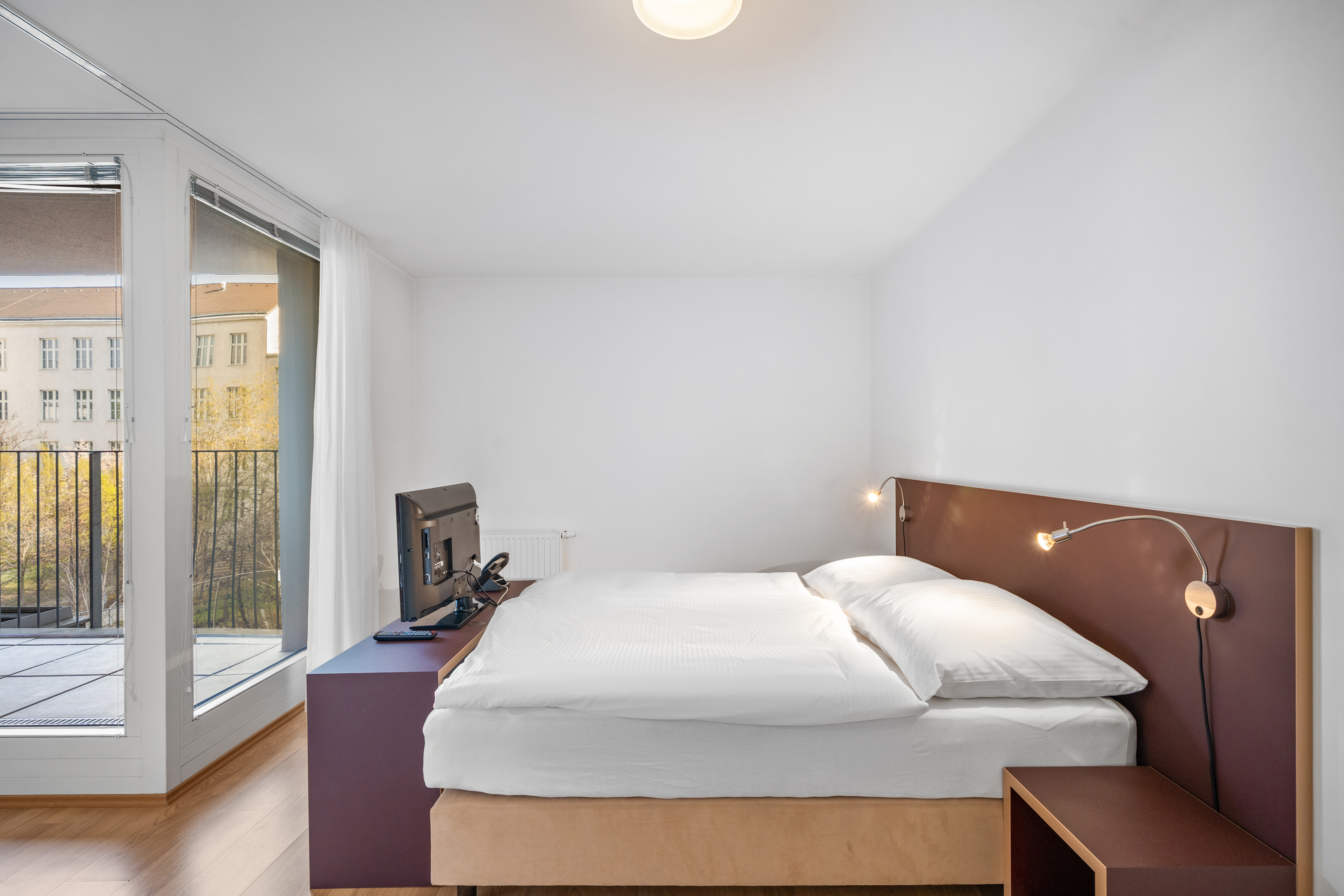 Schlafzimmer mit Doppelbett und braune Bettkopfteil in einem Room4Rent Serviced Apartment Typ M im Storchen&shy;grund
