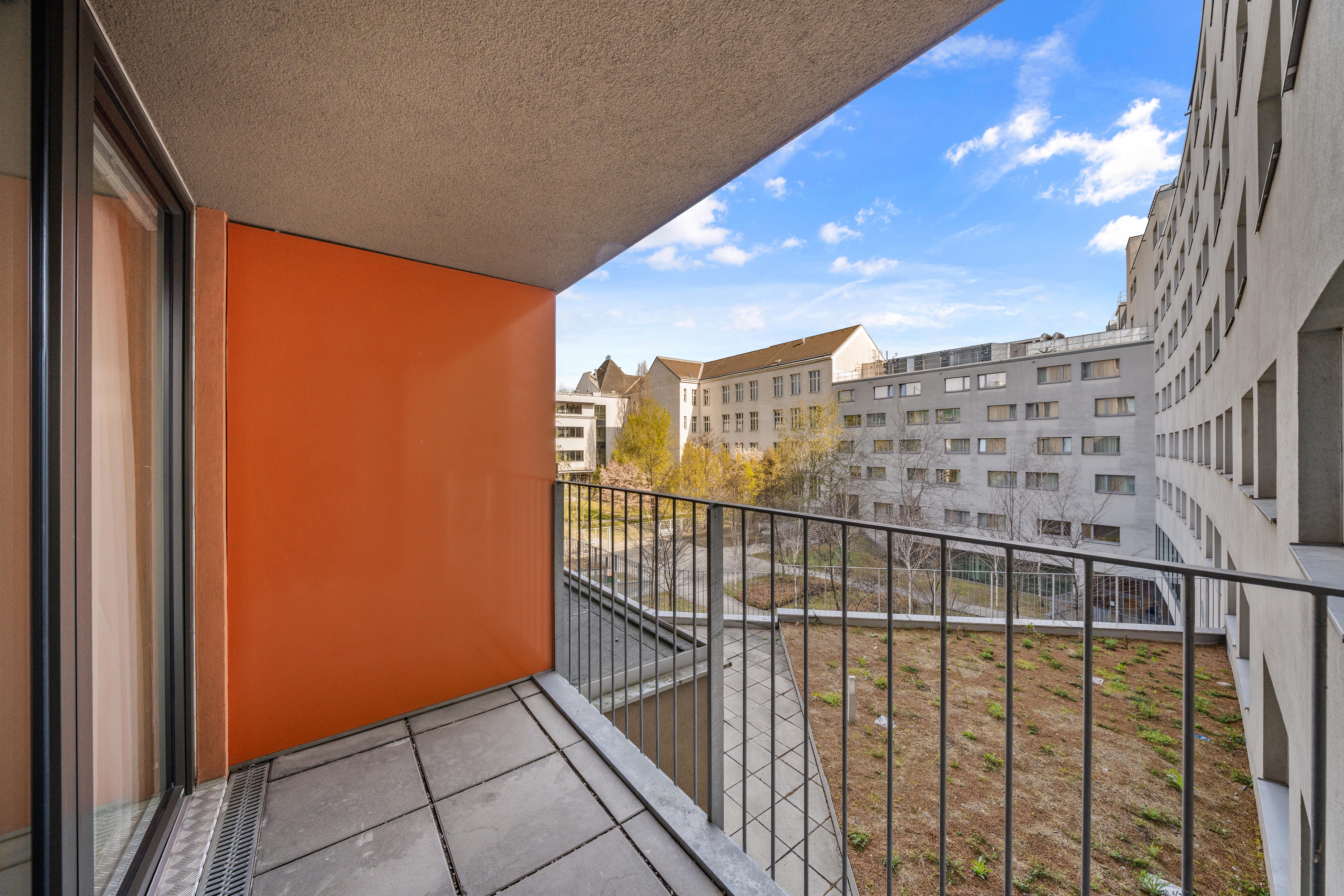 Balkon mit Metallgeländer und Blick auf den Innenhof in einem Room4Rent Serviced Apartment Typ M mit Balkon
