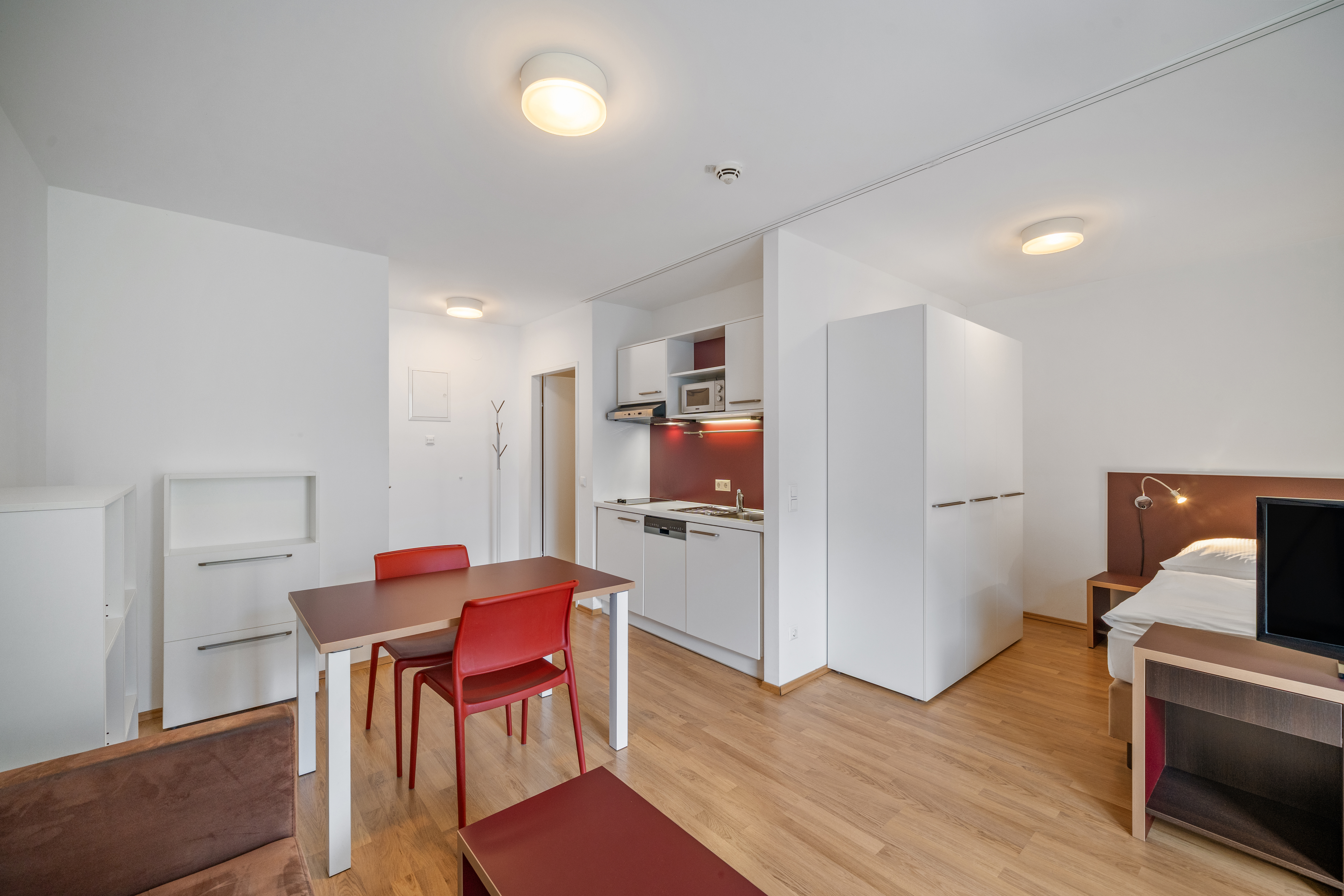 Offene Wohnküche mit Esstisch und Arbeitsbereich neben Schlafzimmer im möblierten Apartment am Storchen&shy;grund