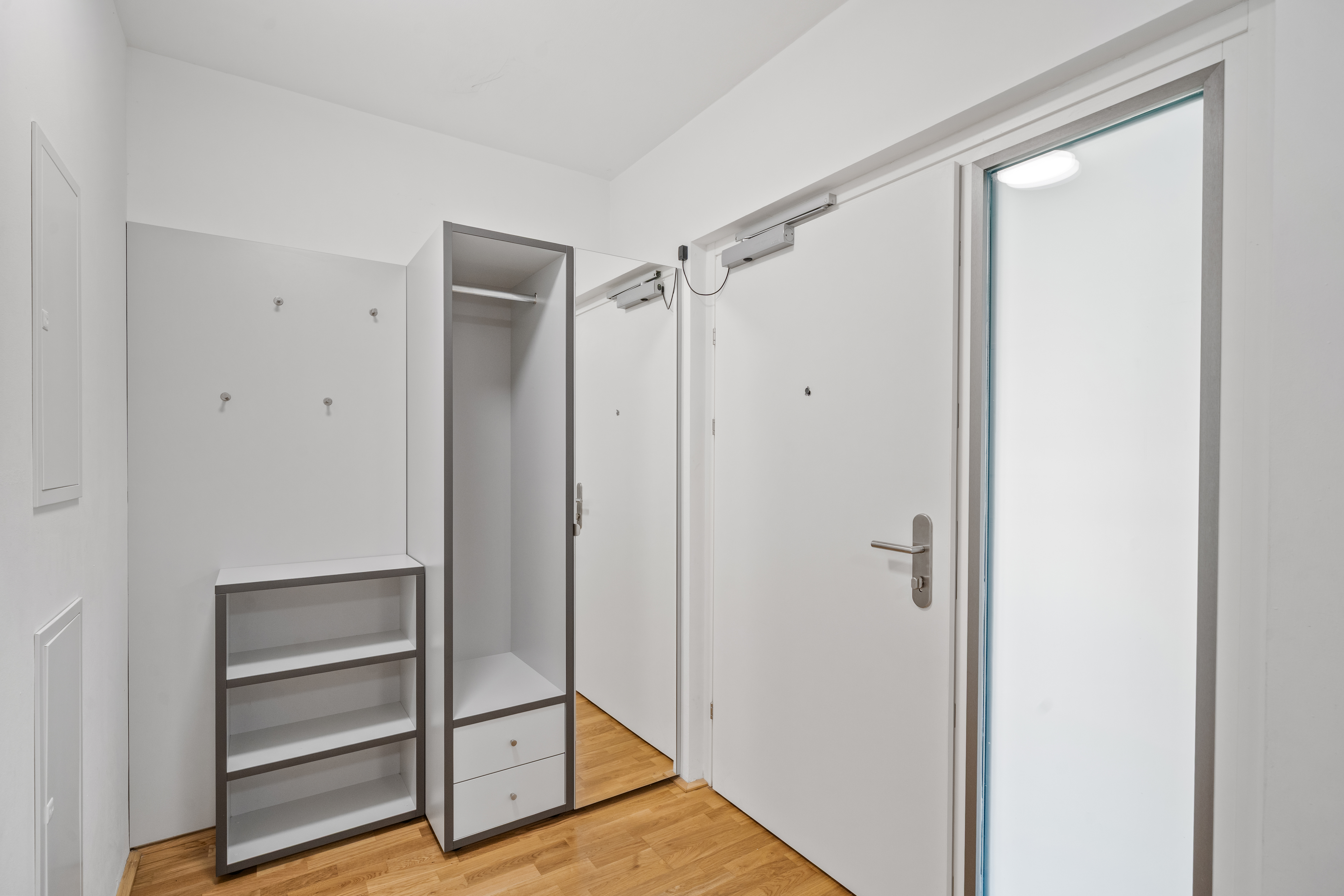 Garderobensbereich mit Regal und Türen in einem möblierten Apartment vom Typ L Balcony