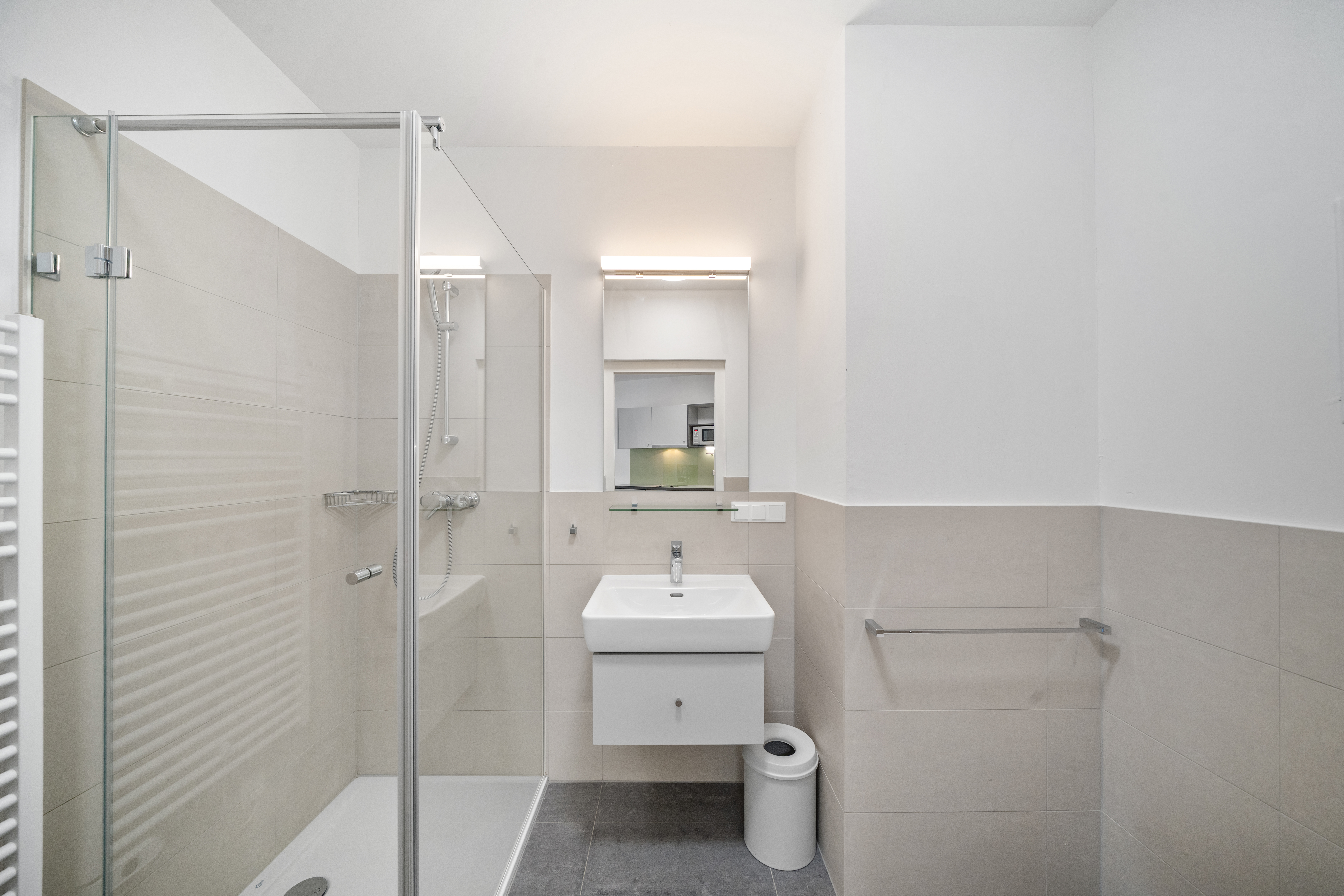 Badezimmer mit Dusche, Waschtisch und WC in einem Room4Rent Apartment Typ M in Vienna Academic Guesthouse