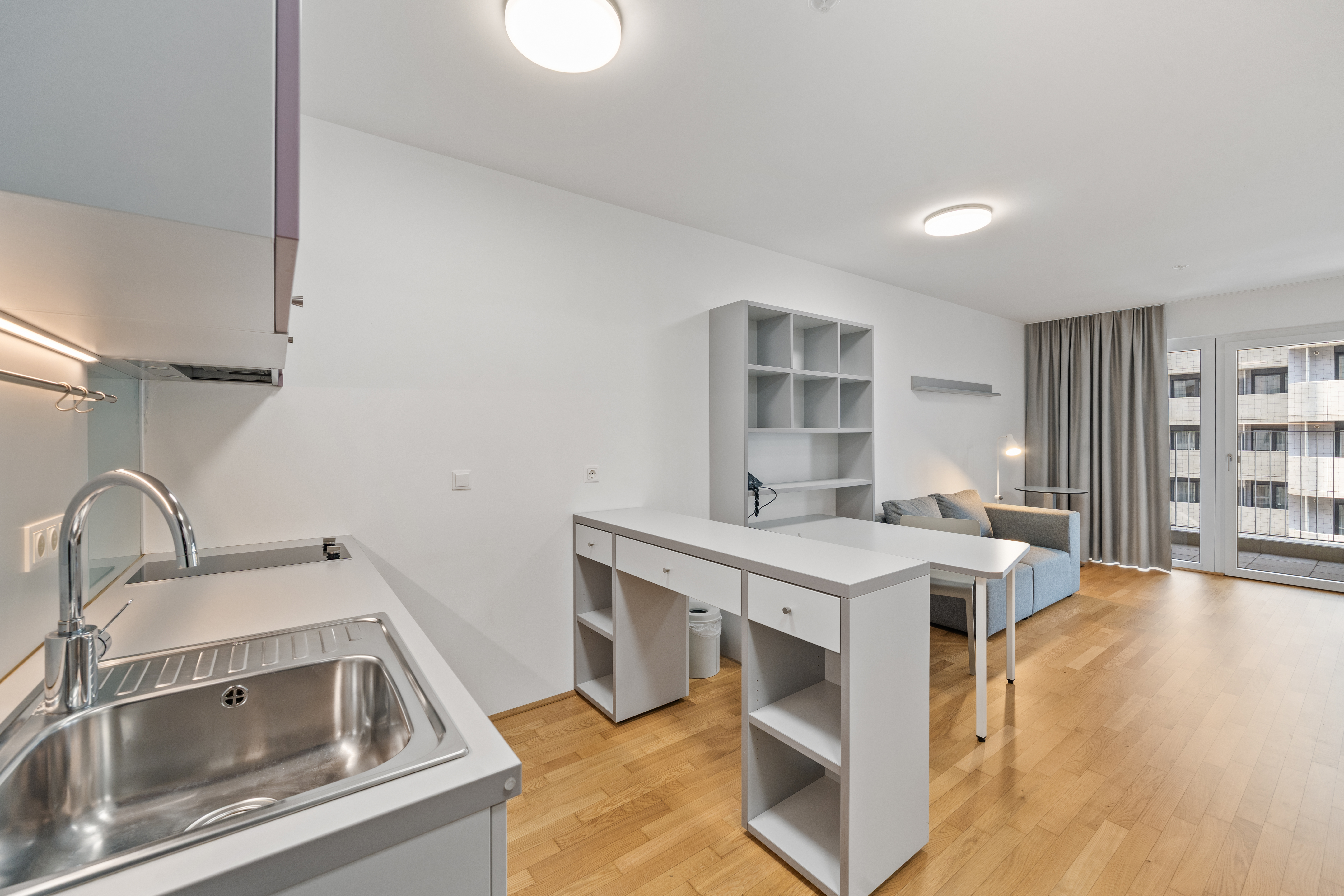 Offene Küche mit Esstheke und Wohnbereich im Vienna BioCenter möblierten Apartment in Wien