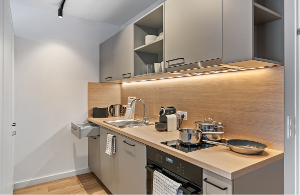 Moderne Küche mit Holzrücwand, vollständiger Ausstattung und Kochfeld in einem Room4Rent Apartment